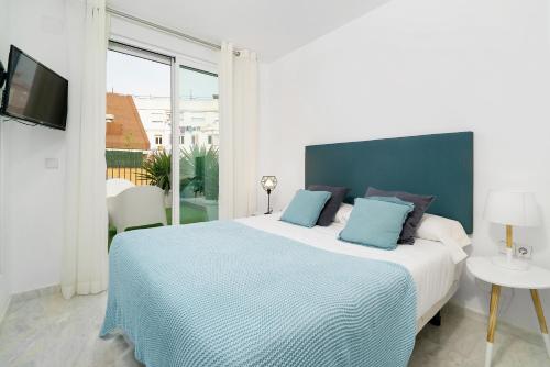 バレンシアにあるFlatsforyou Ruzafaのベッドルーム(青い枕の大型ベッド1台付)