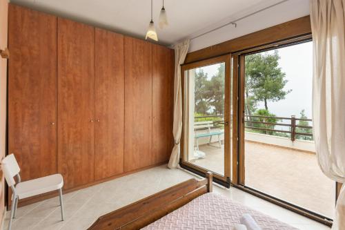 sypialnia z łóżkiem i dużym oknem w obiekcie Beachside Haven, Poolside Serenity & Sunset Magic w mieście Kalandra