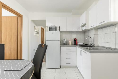 een keuken met witte kasten en een koelkast bij Apartmant Centar Split in Split