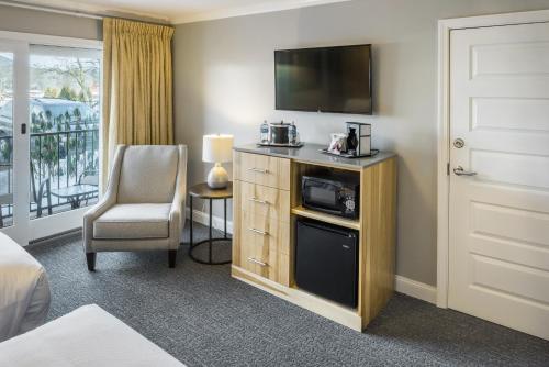 a hotel room with a bed and a television at Center Harbor Inn in Center Harbor
