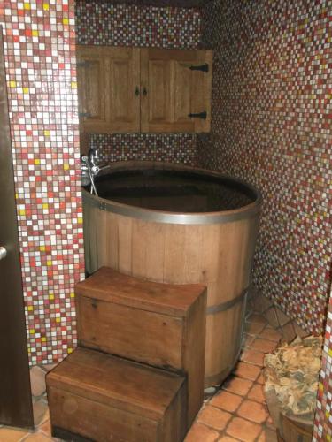 a large wooden tub in a bathroom with tiles at Гостинний двір на хуторі Хрещатик in Khreshchatik