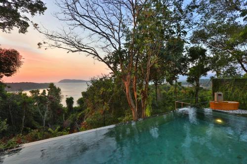 une piscine avec vue sur l'océan dans l'établissement Ambong Pool Villas - Private Pool, à Pantai Cenang