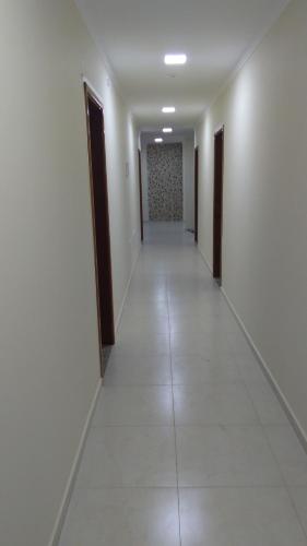 a long hallway with white walls and brown doors at Pousada Circuito das Águas in Caxambu