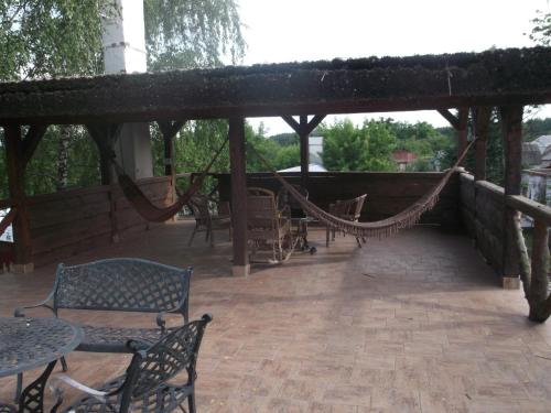 a patio with a hammock and tables and chairs at Гостинний двір на хуторі Хрещатик in Khreshchatik