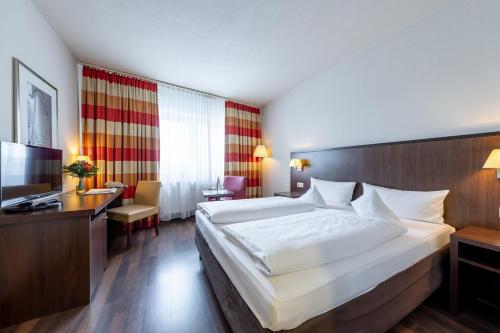 a hotel room with a large bed and a television at Trip Inn Frankfurt Nordwestzentrum in Frankfurt/Main