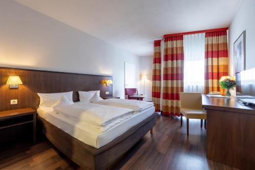 a bedroom with a large bed and a desk and a desk at Trip Inn Frankfurt Nordwestzentrum in Frankfurt/Main