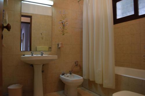 Roja- PéにあるApartamento T2 com Piscina e Wifi a 350 metros da Praiaのバスルーム(洗面台、トイレ、鏡付)