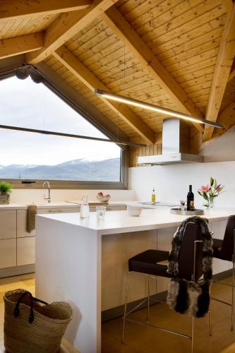 a kitchen with a white counter and a large window at Apartaments Boutique la Torreta del Llac in Puigcerdà