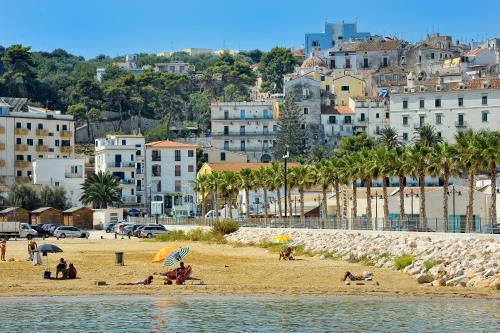 a group of people on a beach with buildings at Hotel Miramare in Rodi Garganico