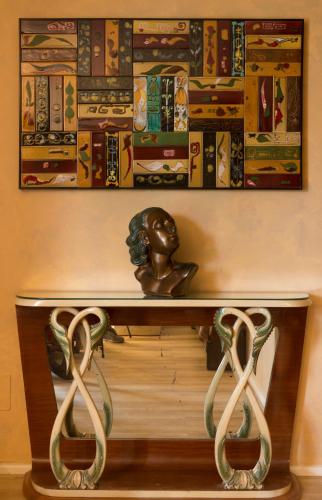 a table with a statue and books on a wall at B&B Villa dei Calchi - Suite Room di Charme in San Felice sul Panaro