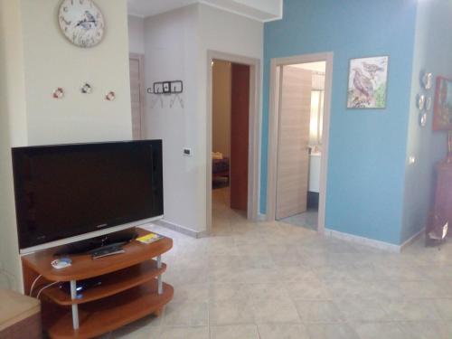 a living room with a flat screen tv on a stand at Finestra sul Mare in Terme Vigliatore
