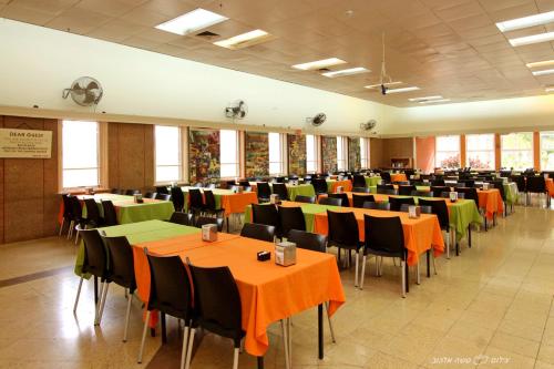 a large room with tables and chairs with orange and green at Degania Bet Kibbutz Country Lodging in Kinneret