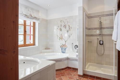 uma casa de banho branca com uma banheira e um lavatório em Das Bergschlössl - very special em Sankt Anton am Arlberg