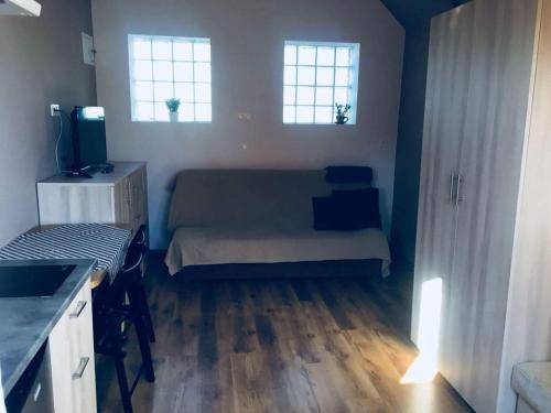 コンティ・リバツキエにあるSiedlisko na Zaciszu domekの小さなベッドルーム(ベッド1台、窓2つ付)が備わります。