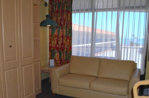 a living room with a couch and a large window at Sun Viking Lodge - Daytona Beach in Daytona Beach