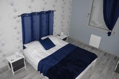 a bedroom with a bed with a blue curtain at les gîtes de la cuesta in Henneveux