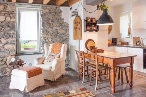 cocina con mesa, sillas y pared de piedra en Holiday Home Vista Lago, en Cernobbio