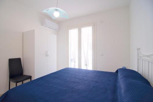ein Schlafzimmer mit einem blauen Bett und einem Stuhl in der Unterkunft Aria di Mare in Casal Velino