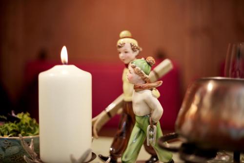 a candle and a statue of a man holding a woman at Das Bergschlössl - very special in Sankt Anton am Arlberg