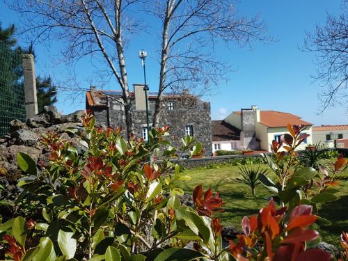 a garden with flowers in front of a building at StoneWood Lodge AL in São Vicente Ferreira