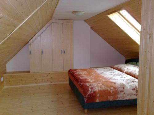 a attic bedroom with a bed and a skylight at Ubytovani U Kulky in Kyjov
