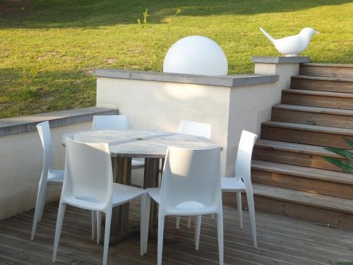 - une table et des chaises sur une terrasse avec des escaliers dans l'établissement L'Eugenie, à Pierrefonds