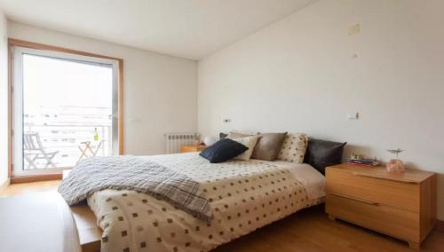 um quarto com uma cama com uma cómoda em madeira e uma janela em My Oriente em Lisboa