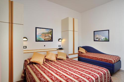 Postel nebo postele na pokoji v ubytování Hotel Amedeo