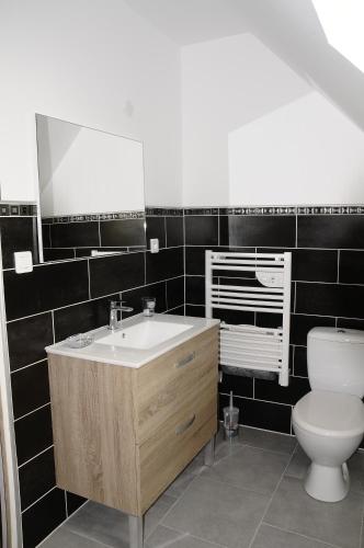 a bathroom with a sink and a toilet at les gîtes de la cuesta in Henneveux