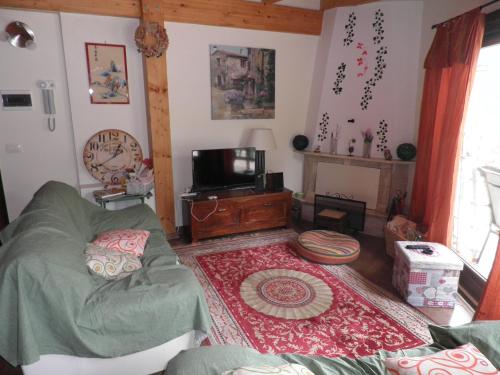 sala de estar con sofá y TV en La casa tra gli alberi, en Fiuggi