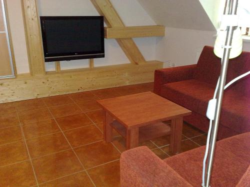 a living room with a tv and a couch and a table at Ubytovani U Kulky in Kyjov