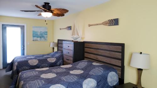 1 Schlafzimmer mit 2 Betten und einem Deckenventilator in der Unterkunft Put-in-Bay Waterfront Condo #207 in Put-in-Bay