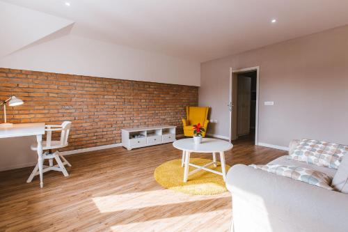 a living room with a couch and a brick wall at Apartma Lilly in Bled