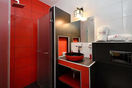 a bathroom with red walls and a red sink at Eden's Boutique in Had Nes
