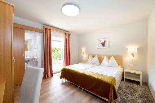 una camera d'albergo con letto e finestra di Gästehaus Wrann a Velden am Wörthersee