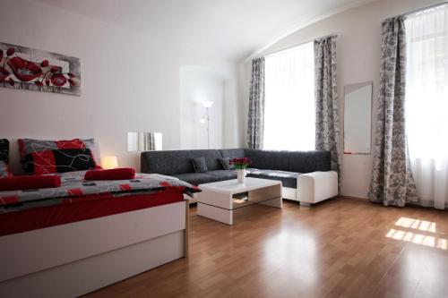 a bedroom with a bed and a couch and a table at Family Duplex on Wenceslas square in Prague