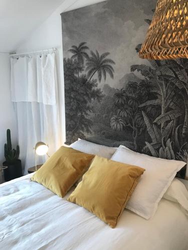 une chambre avec un lit blanc avec un tableau sur le mur dans l'établissement Appartement Casalea - Casadibastia - Bastia centre, à Bastia