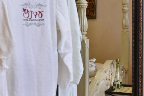 a white towel hanging in a bathroom next to a sink at Eden's Boutique in Had Nes