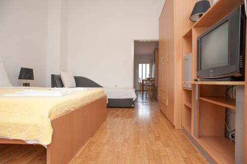 a room with a bed and a tv in a room at Apartment Mina in Sveti Stefan