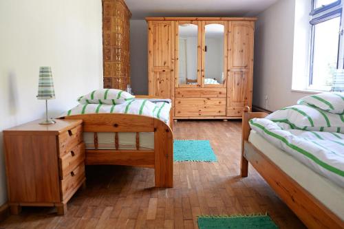 ein Schlafzimmer mit zwei Betten, einer Kommode und einem Spiegel in der Unterkunft Retrodom in Retowo