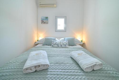 a bedroom with a large bed with towels on it at Holiday house Mala in Sinj