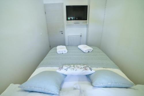 a small room with two beds with blue pillows at Holiday house Mala in Sinj