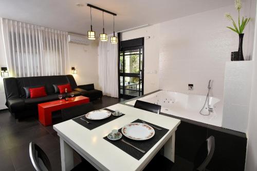 a kitchen and living room with a table and a couch at Eden's Boutique in Had Nes