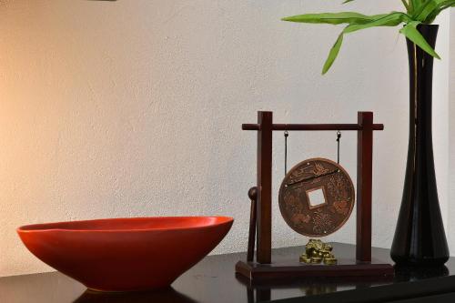 a bowl and a clock on a table with a plant at Eden's Boutique in Had Nes