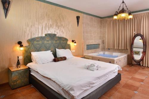 a bedroom with a large bed and a tub at Eden's Boutique in Had Nes