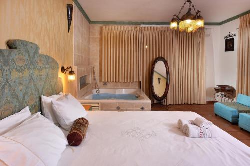 a bedroom with a large bed and a tub at Eden's Boutique in Had Nes