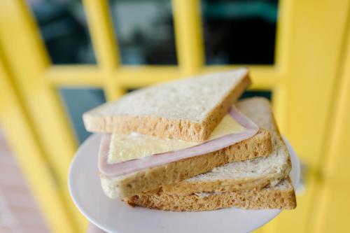 a sandwich is cut in half on a plate at Chez Bure - Bure Homestay in Kanchanaburi