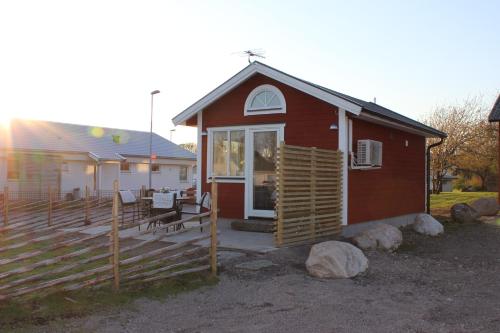 a small red house with a porch and a fence at Smeakalles in Tvååker