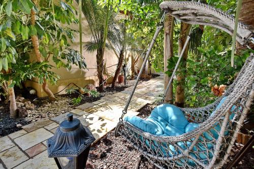 a swinging hammock in a garden with trees at Eden's Boutique in Had Nes