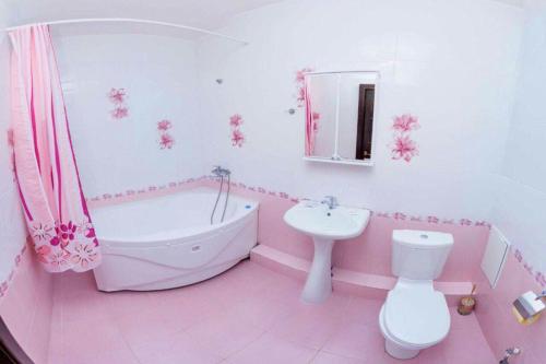 チュメニにあるApartment on Gazovikov 41のピンクのバスルーム(バスタブ、洗面台、トイレ付)